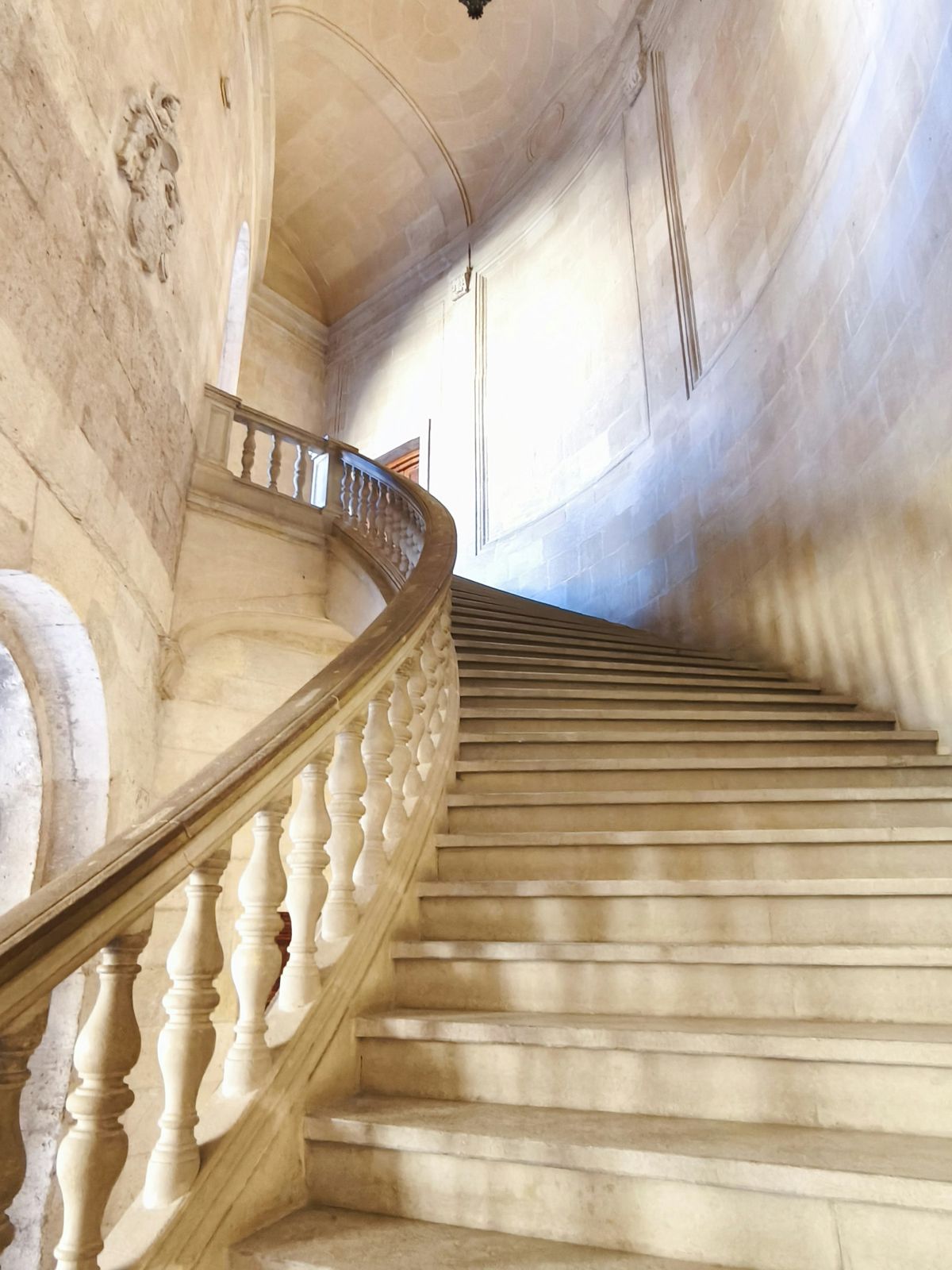 Escalier de pierre à balustrade baigné de lumière naturelle